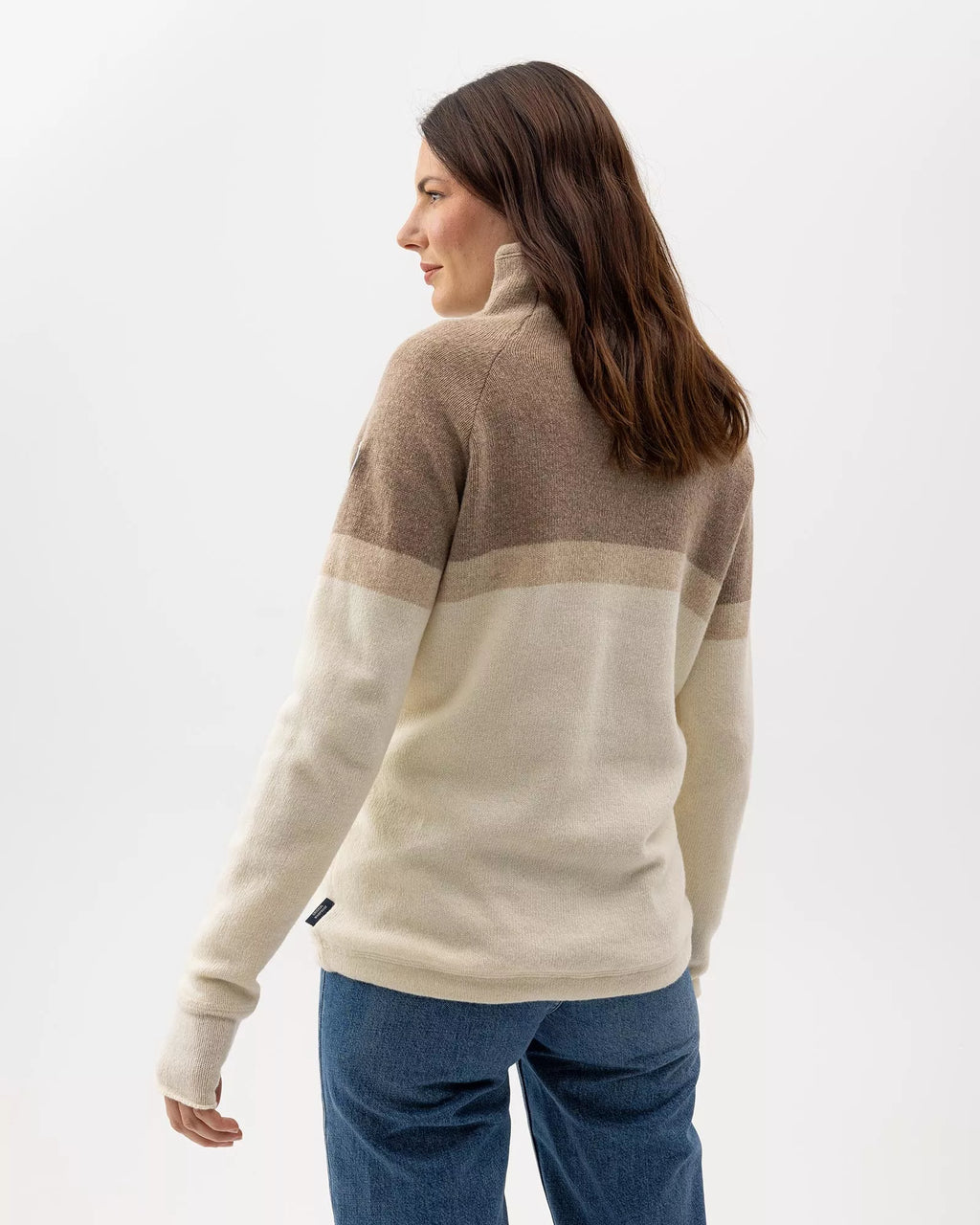 Woman wearing a beige and brown color-blocked sweater on a white background