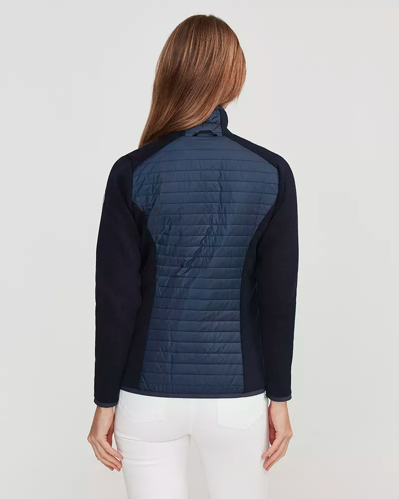 Person wearing a navy quilted jacket on a white background