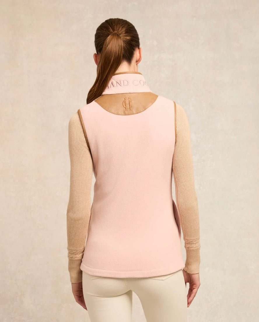 Woman wearing a pink sweater with beige sleeves on a beige background