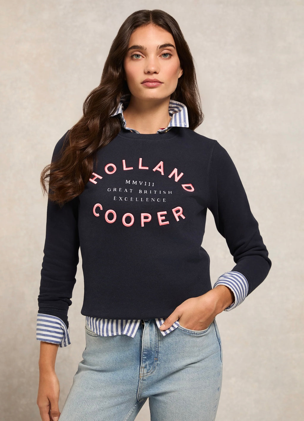 Woman wearing a black 'Holland Cooper' sweatshirt with a beige background