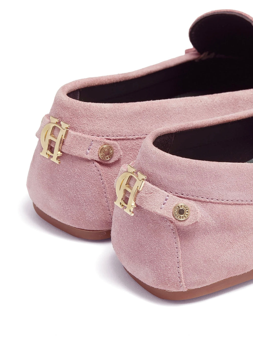 Pink suede shoes with gold buckles on a white background