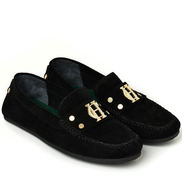 Black loafers with gold buckles on a white background