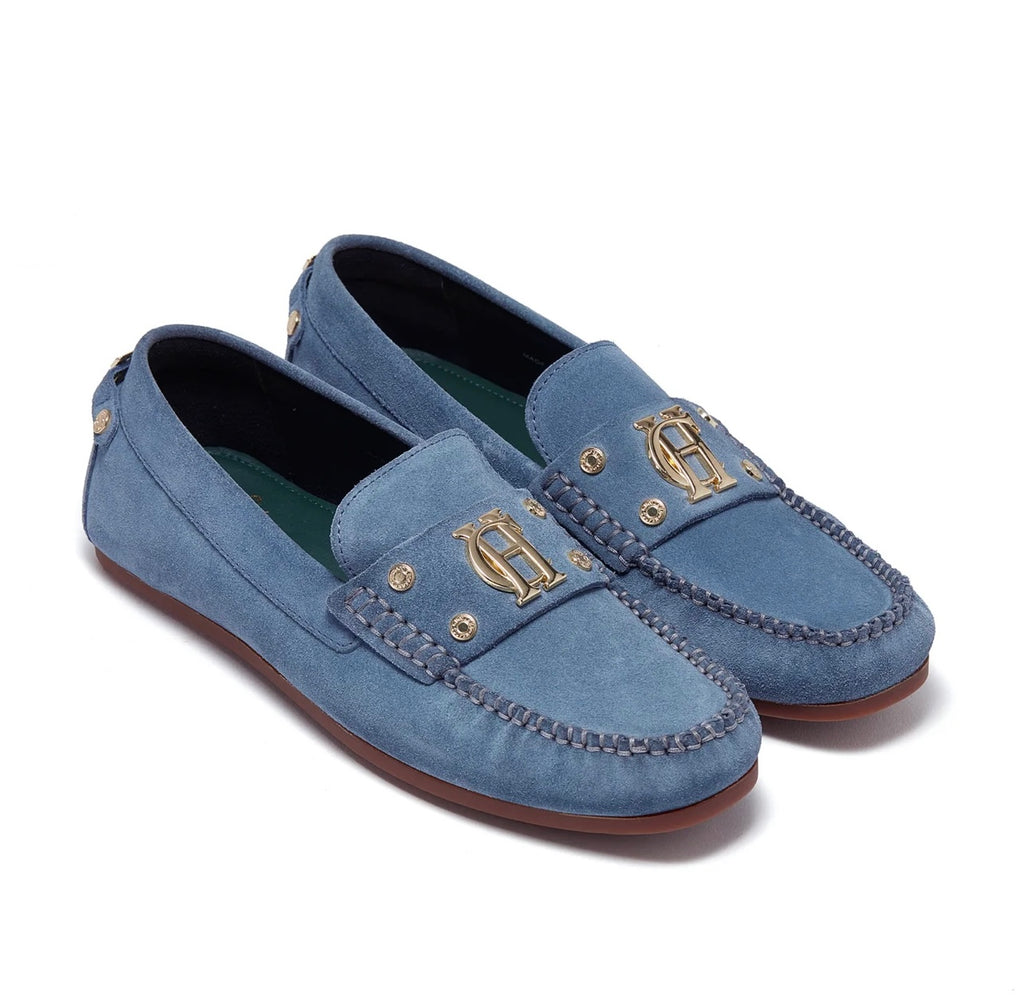 Pair of blue loafers with gold accents on a white background