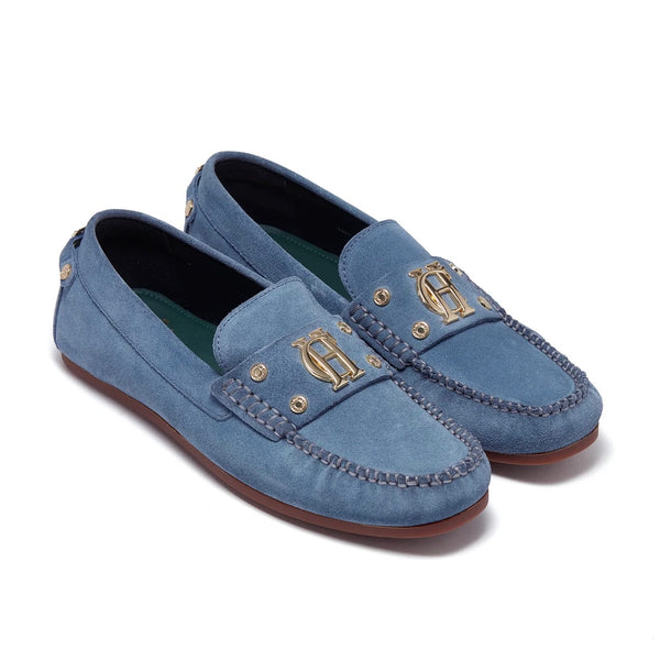Pair of blue loafers with gold accents on a white background