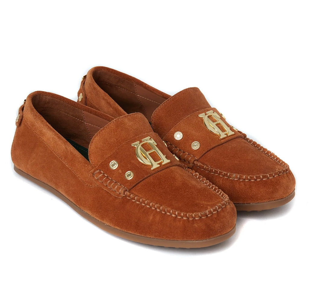 Pair of brown suede loafers with gold monogram on a white background