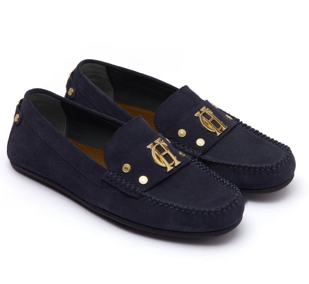 Navy loafers with gold accents on a white background