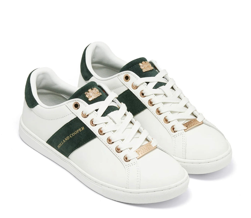 White sneakers with green accents and gold branding on a white background