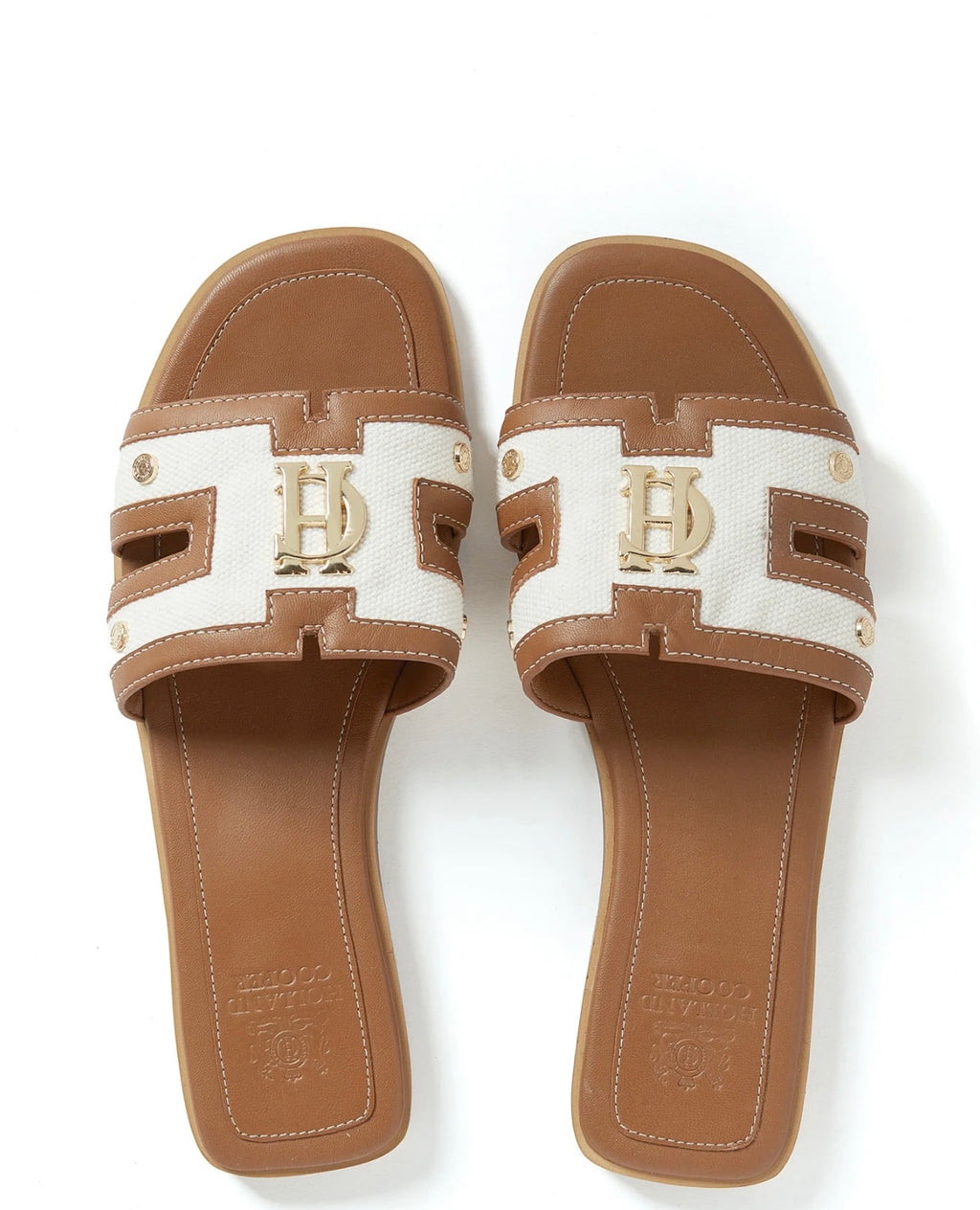 Pair of brown and white sandals with a logo on a white background