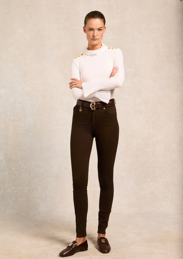 Person wearing a white top and black pants with a belt on a neutral background