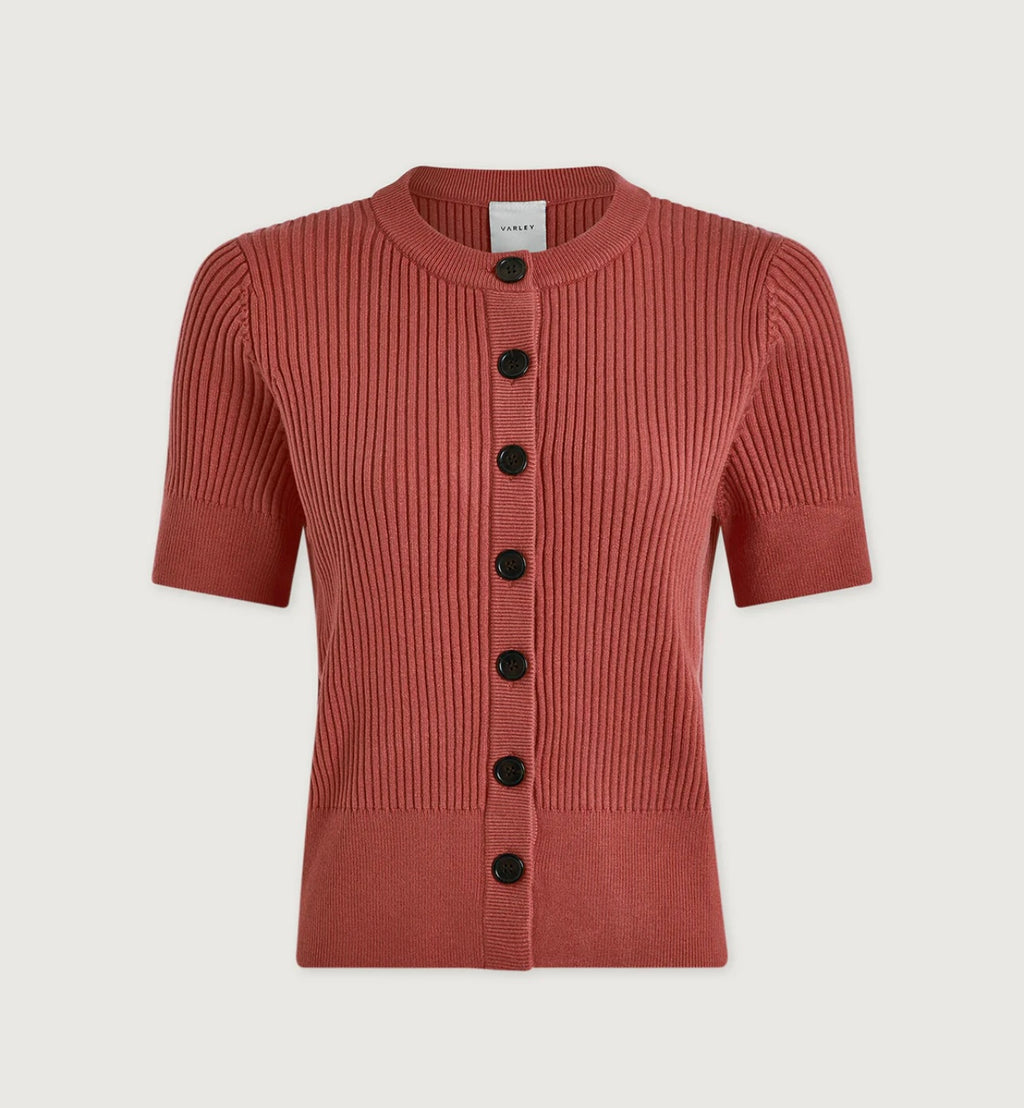 Rust-colored ribbed knit cardigan with black buttons on a light beige background