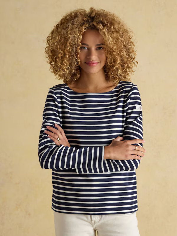 Woman wearing a navy and white striped shirt against a beige background