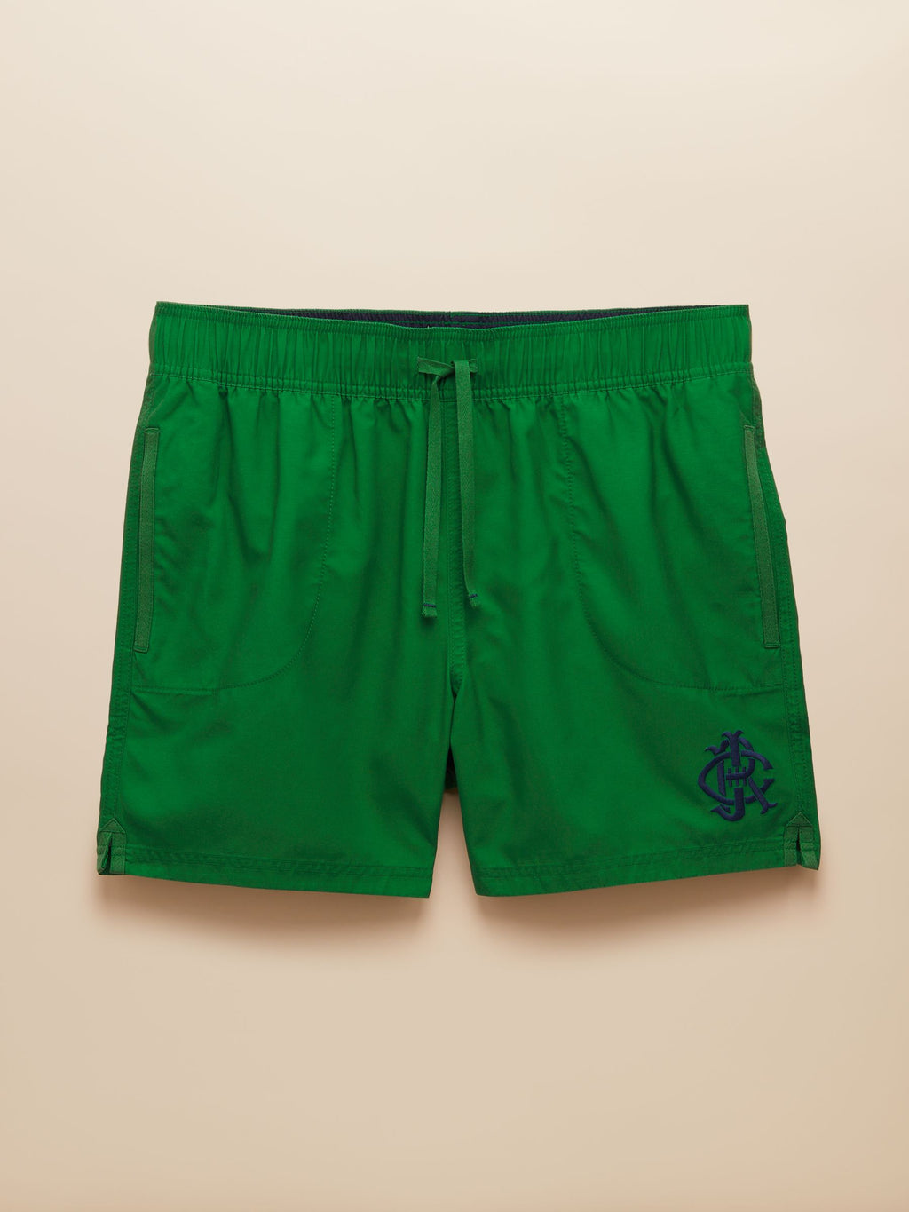 Green shorts with a logo on a beige background