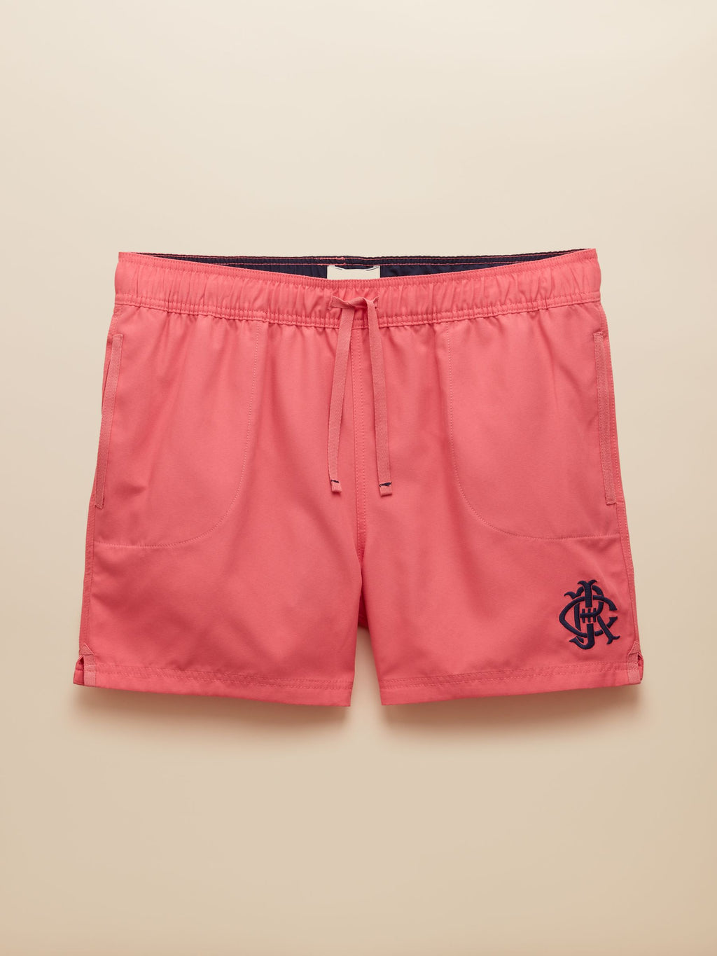 Pink shorts with a logo on a beige background