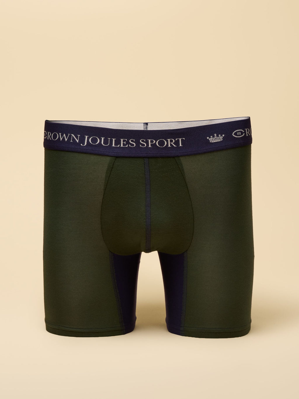 Green boxer briefs with navy waistband on a beige background