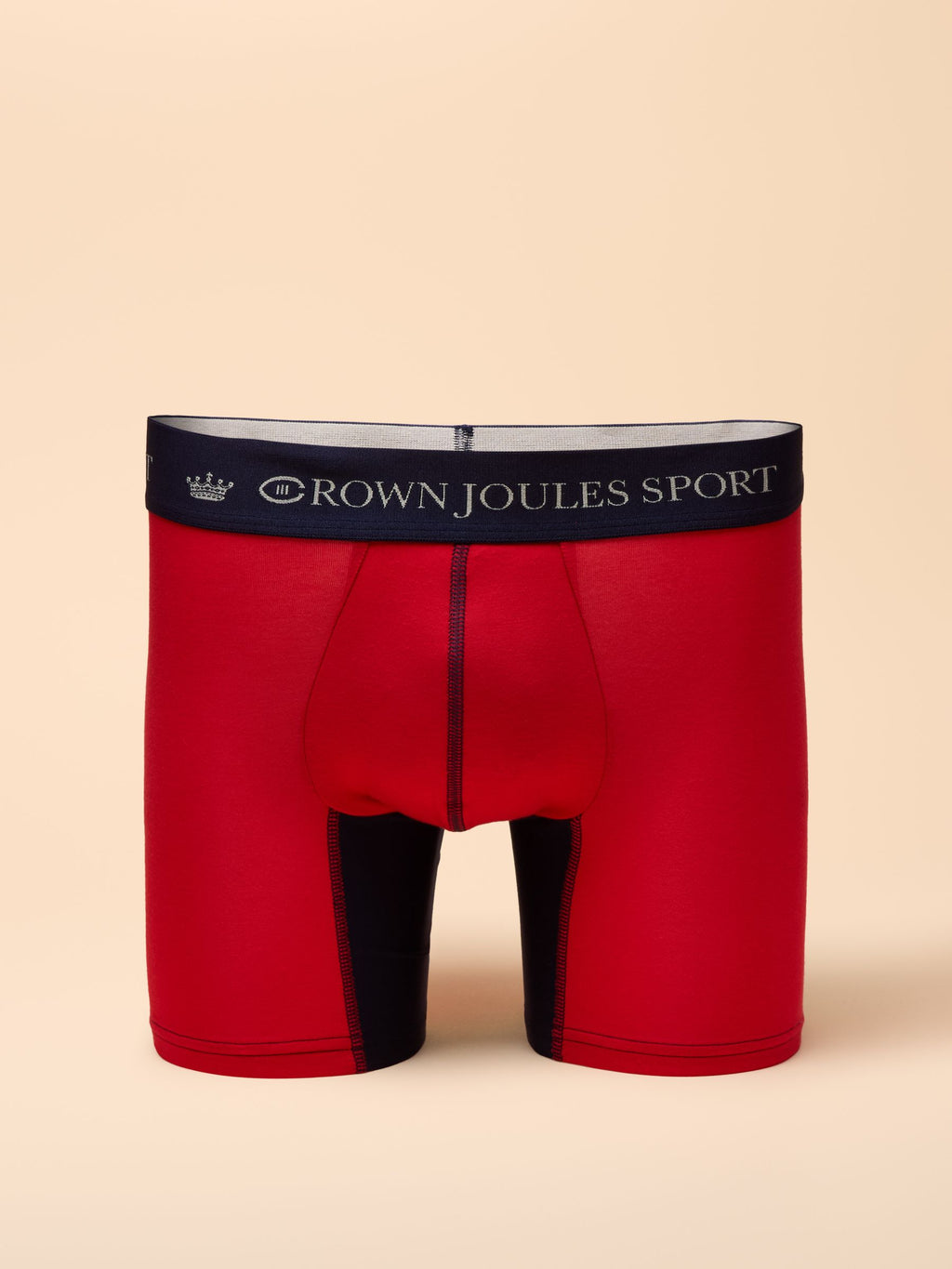 Red boxer briefs with black waistband on a beige background