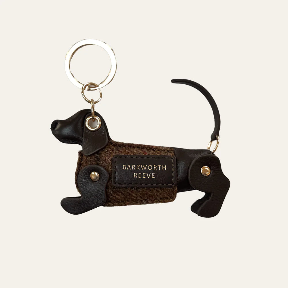 Dog-shaped keychain with 'Barkworth Reeve' branding on a beige background