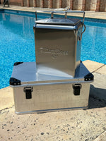 Metal box with a lid on a poolside ledge