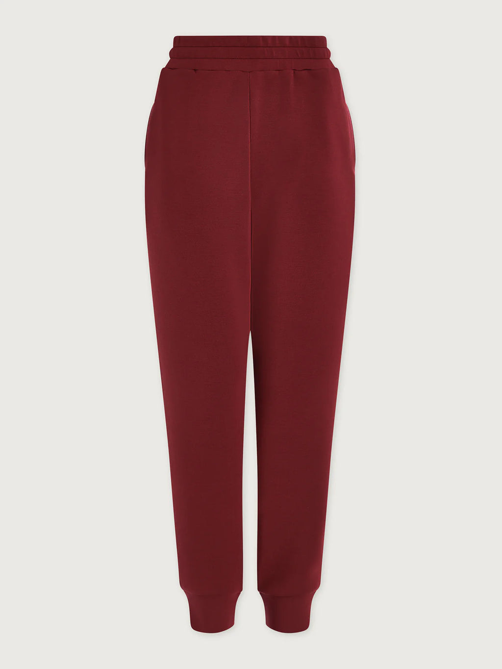 Maroon sweatpants on a light beige background