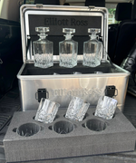 Four glass bottles in a metal holder with a black background