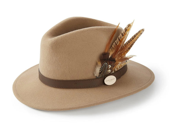 Tan hat with a brown band and feather decoration on a white background