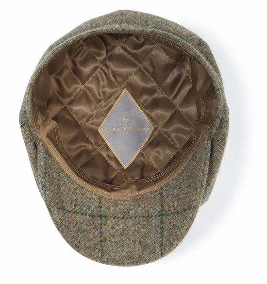 Green checkered flat cap with quilted interior on a white background