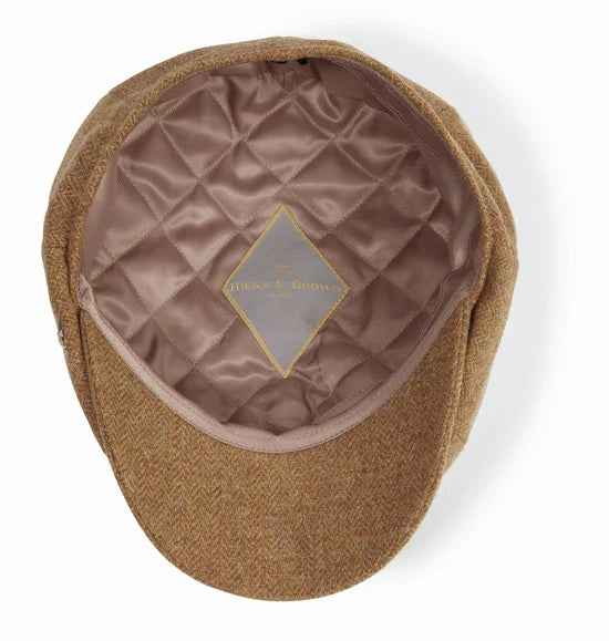 Brown flat cap with quilted interior on a white background