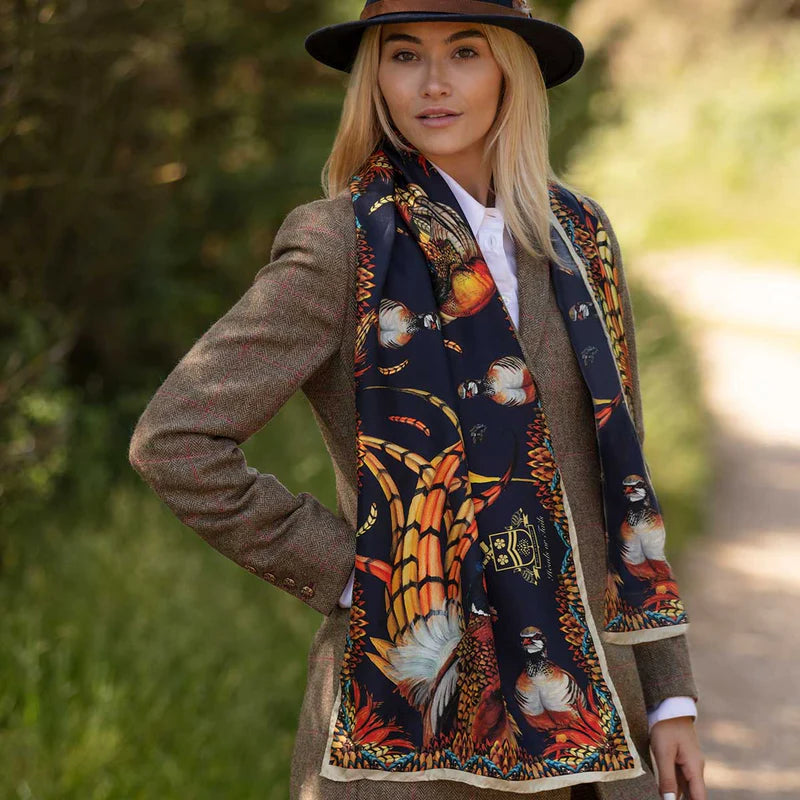 Woman wearing a patterned scarf outdoors with blurred greenery in the background