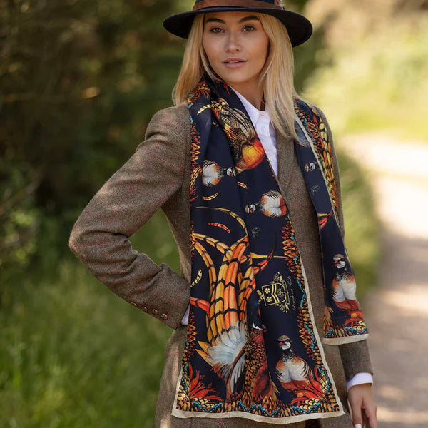 Woman wearing a patterned scarf outdoors with blurred greenery in the background