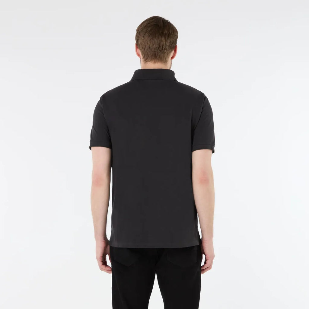 Person wearing a black polo shirt on a white background