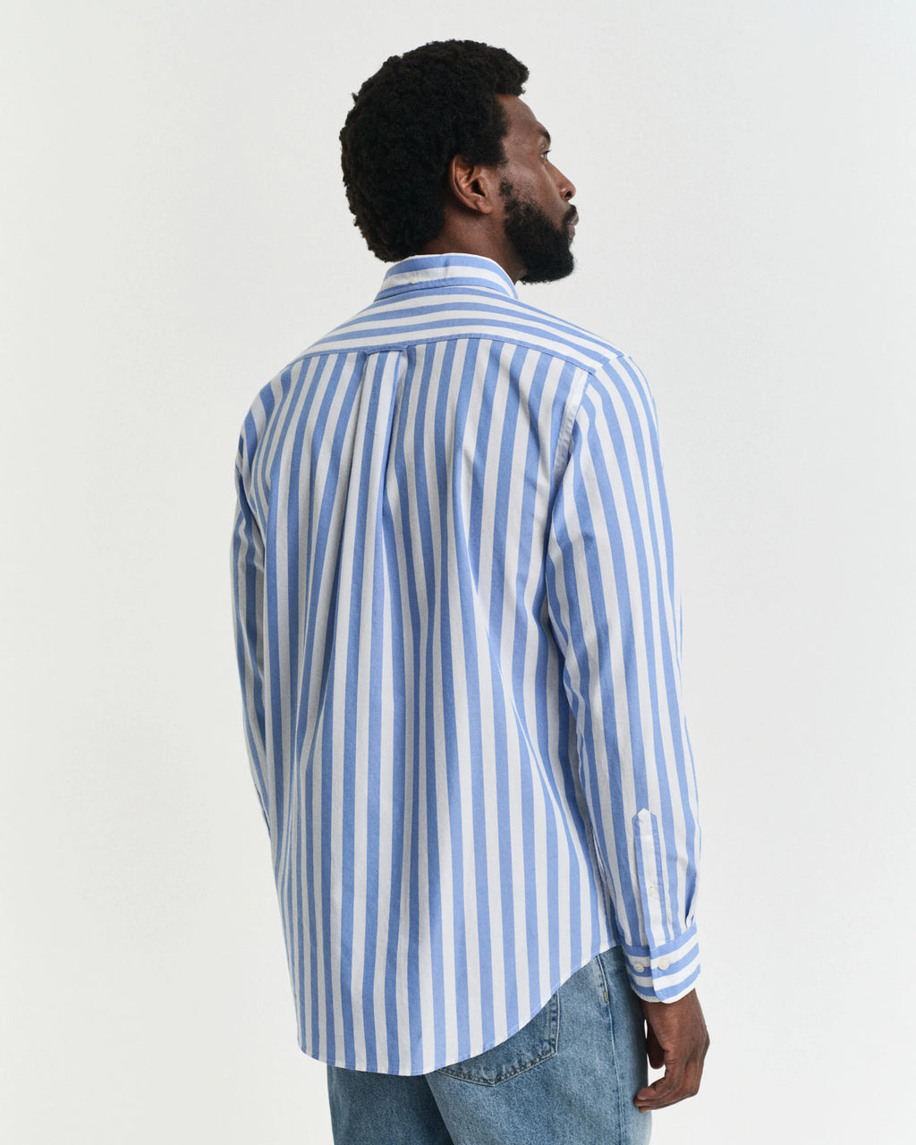 Man wearing a blue and white striped shirt against a plain background