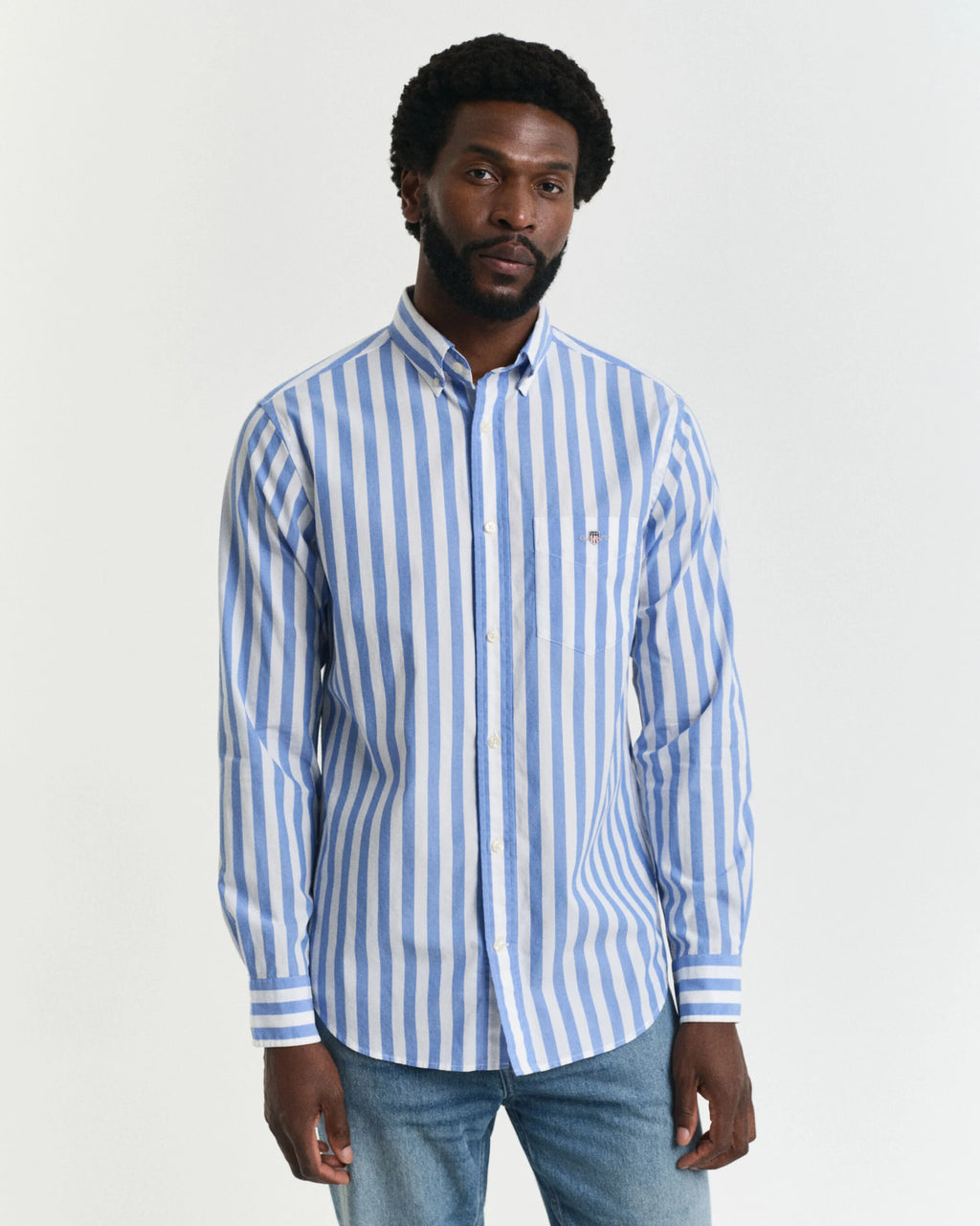 Man wearing a blue and white striped shirt against a plain background