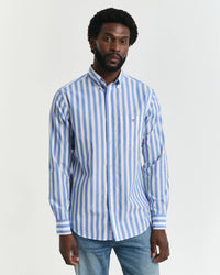 Man wearing a blue and white striped shirt against a plain background