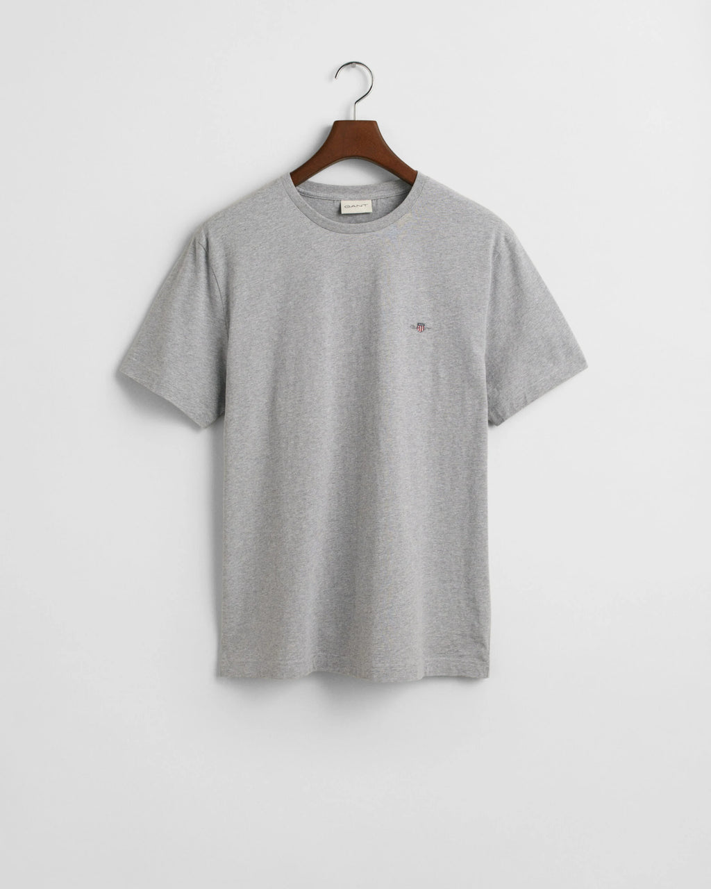 Gray t-shirt on a hanger against a light gray background