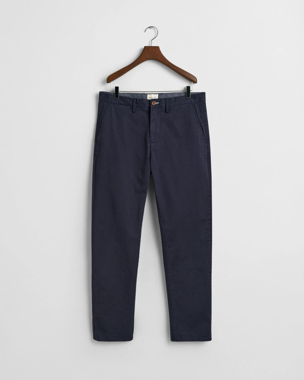 Navy blue pants on a hanger against a white background