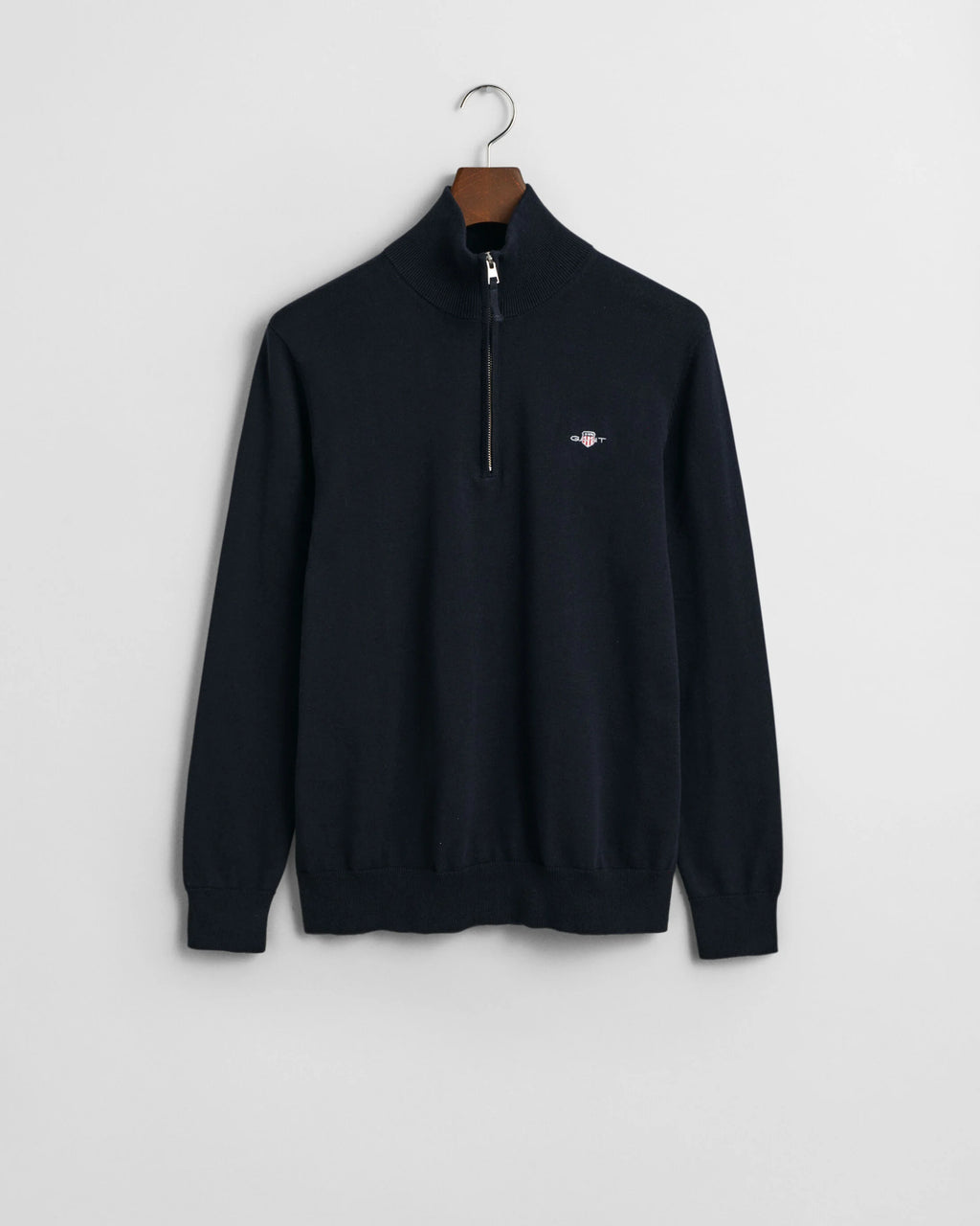 Black half-zip sweater on a hanger against a white background