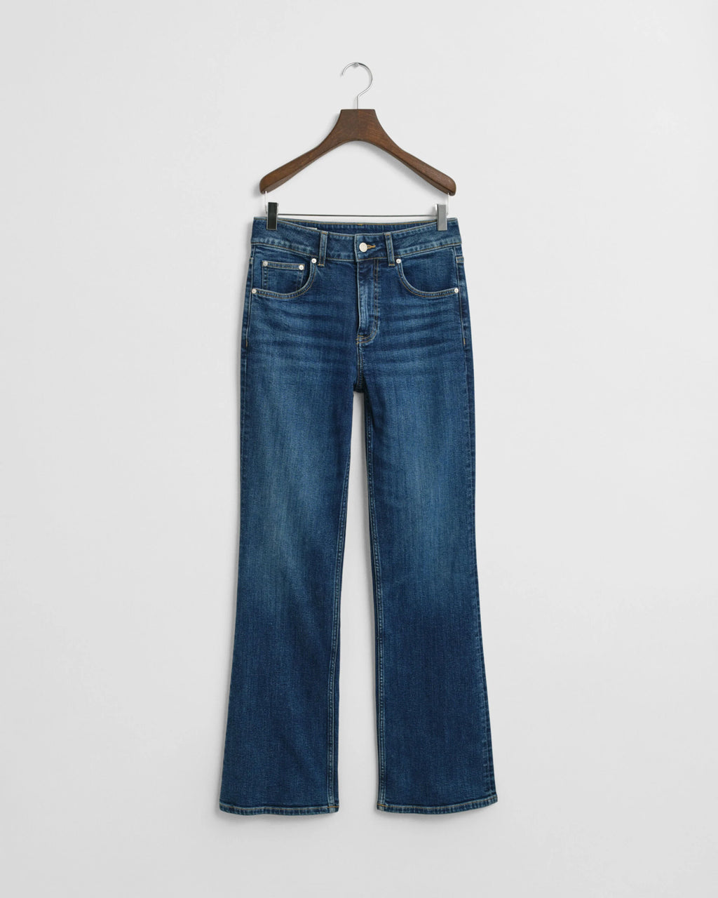 Blue jeans on a hanger against a white background