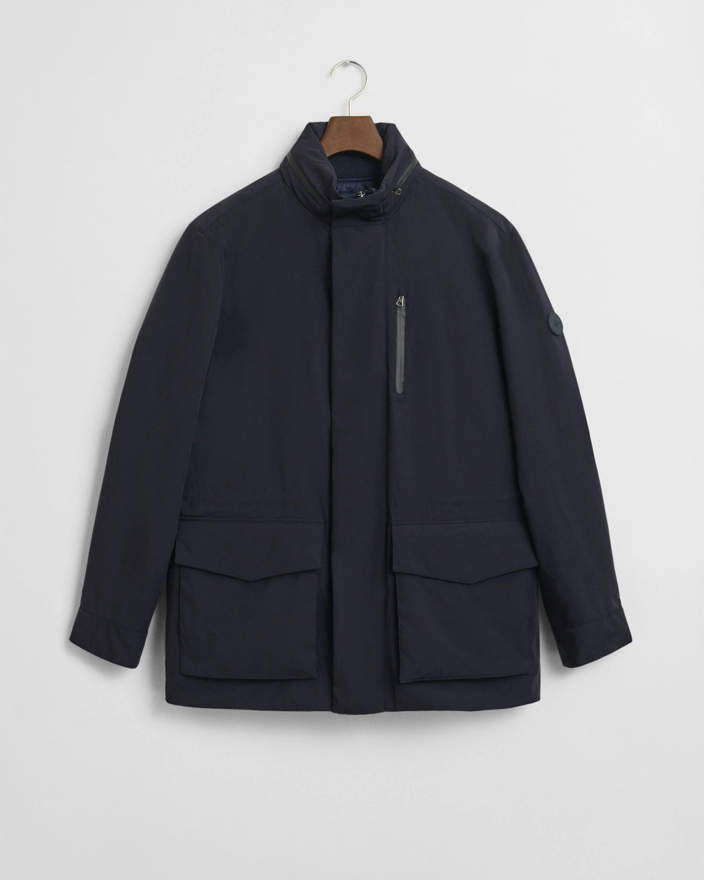 Navy jacket on a hanger against a light gray background