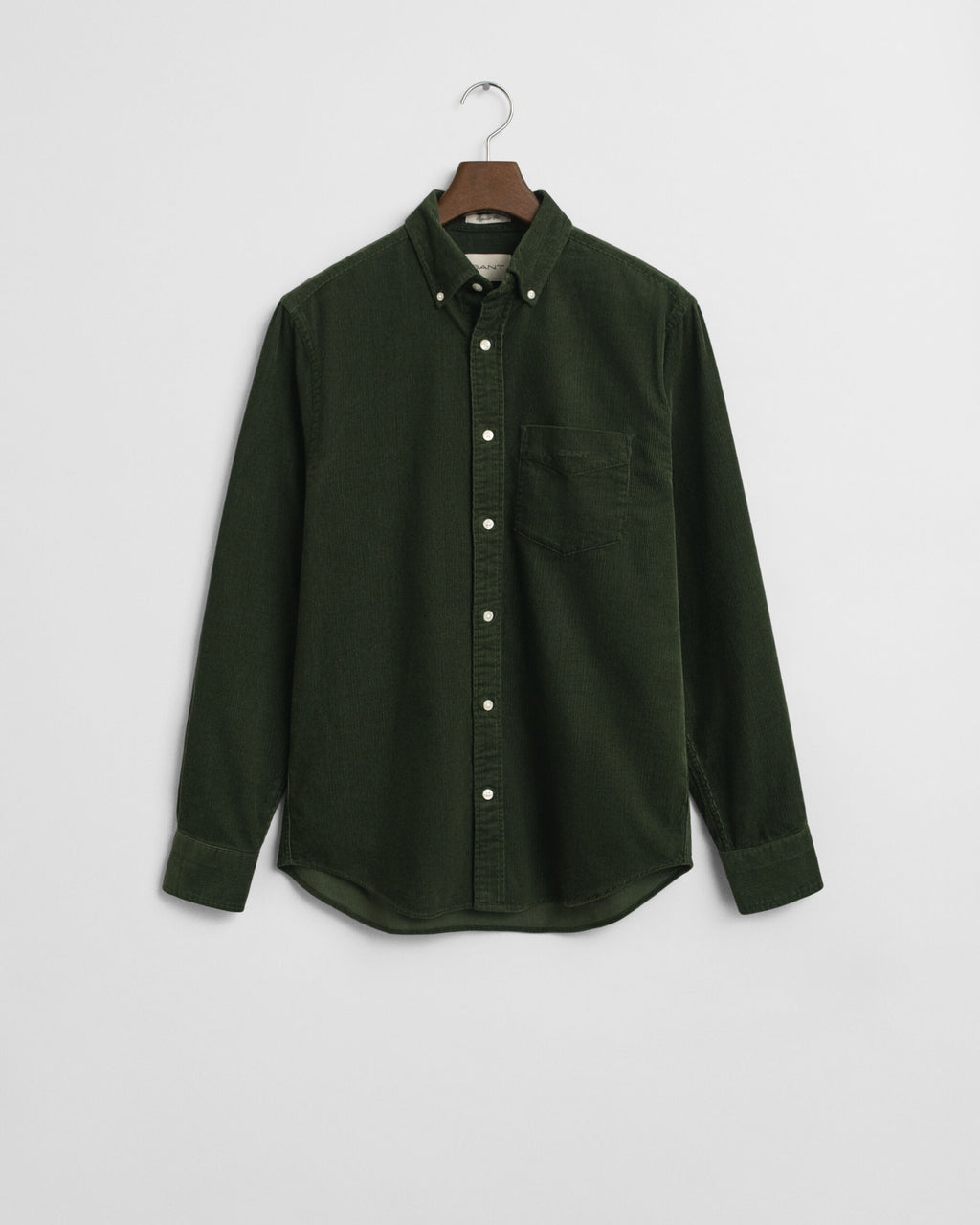 Green shirt on a hanger against a light gray background