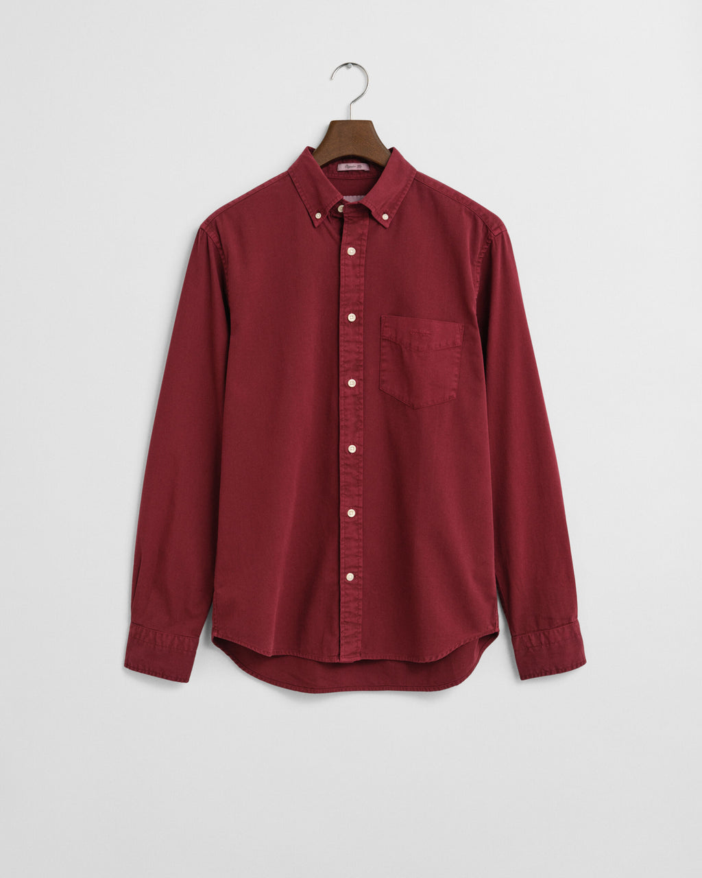 Red shirt on a hanger against a white background