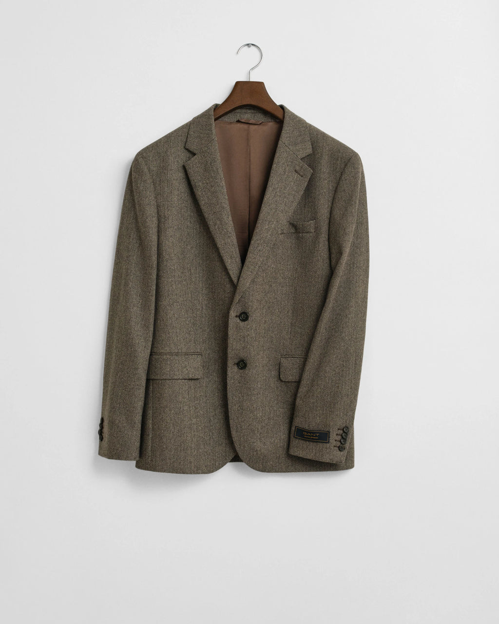 Brown blazer on a hanger against a light gray background