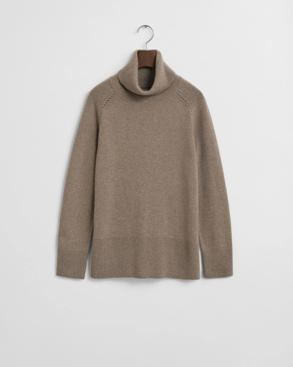 Beige turtleneck sweater on a hanger against a white background