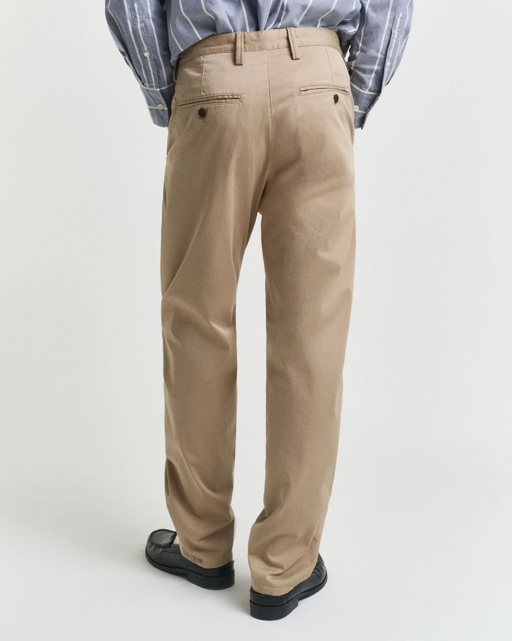 Person wearing beige pants on a white background