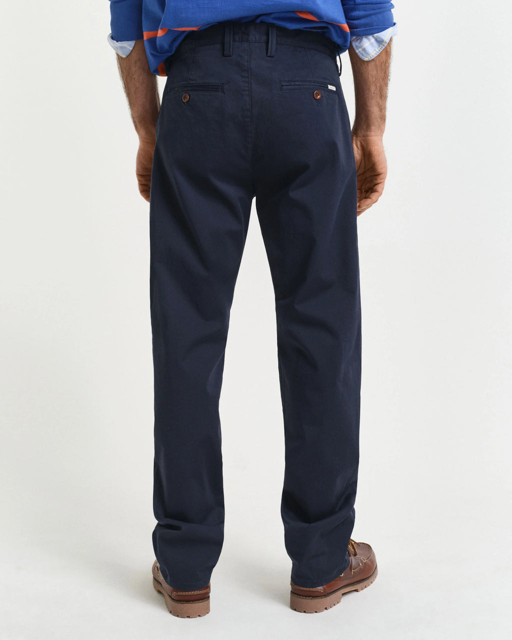 Navy pants worn by a person on a white background