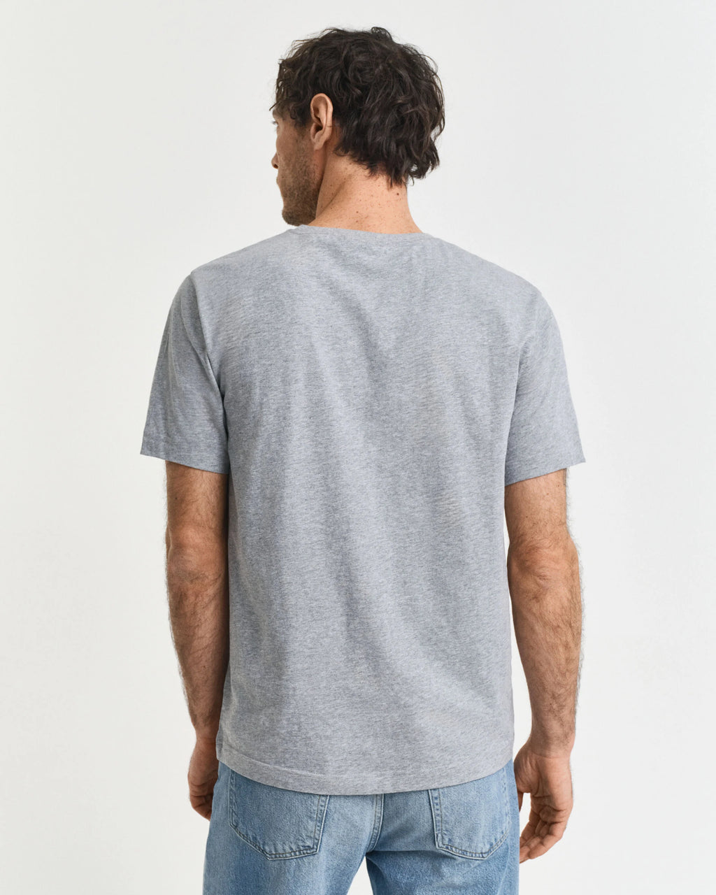 Man wearing a gray t-shirt on a plain background