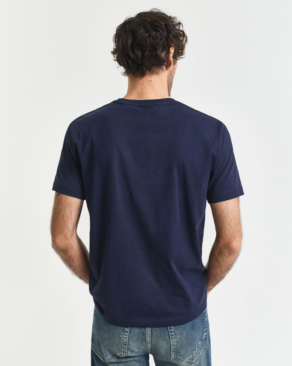 Man wearing a navy blue t-shirt on a light gray background