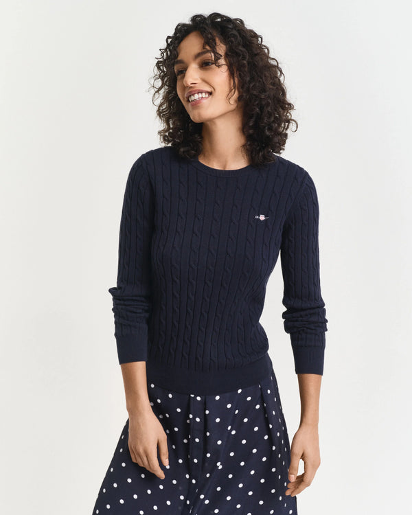 Woman wearing a navy sweater with a white background