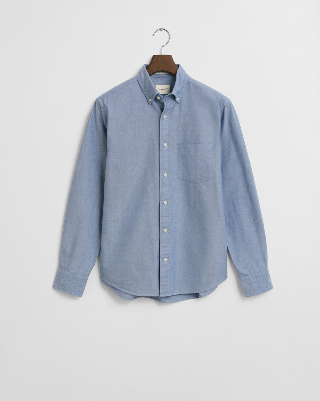 Blue shirt on a hanger against a light gray background