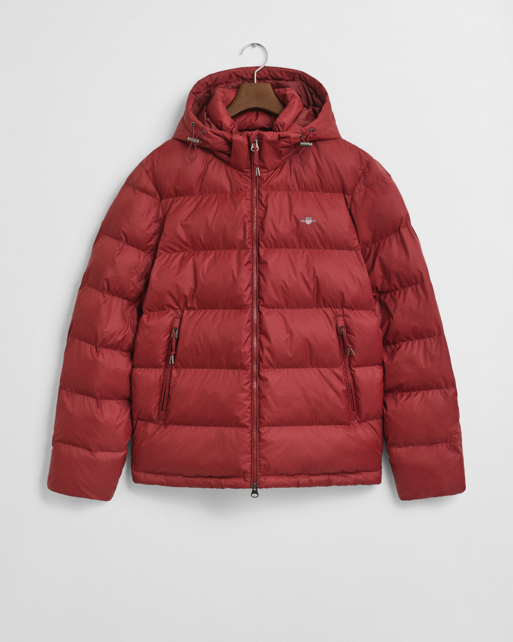 Red puffer jacket on a hanger against a light gray background