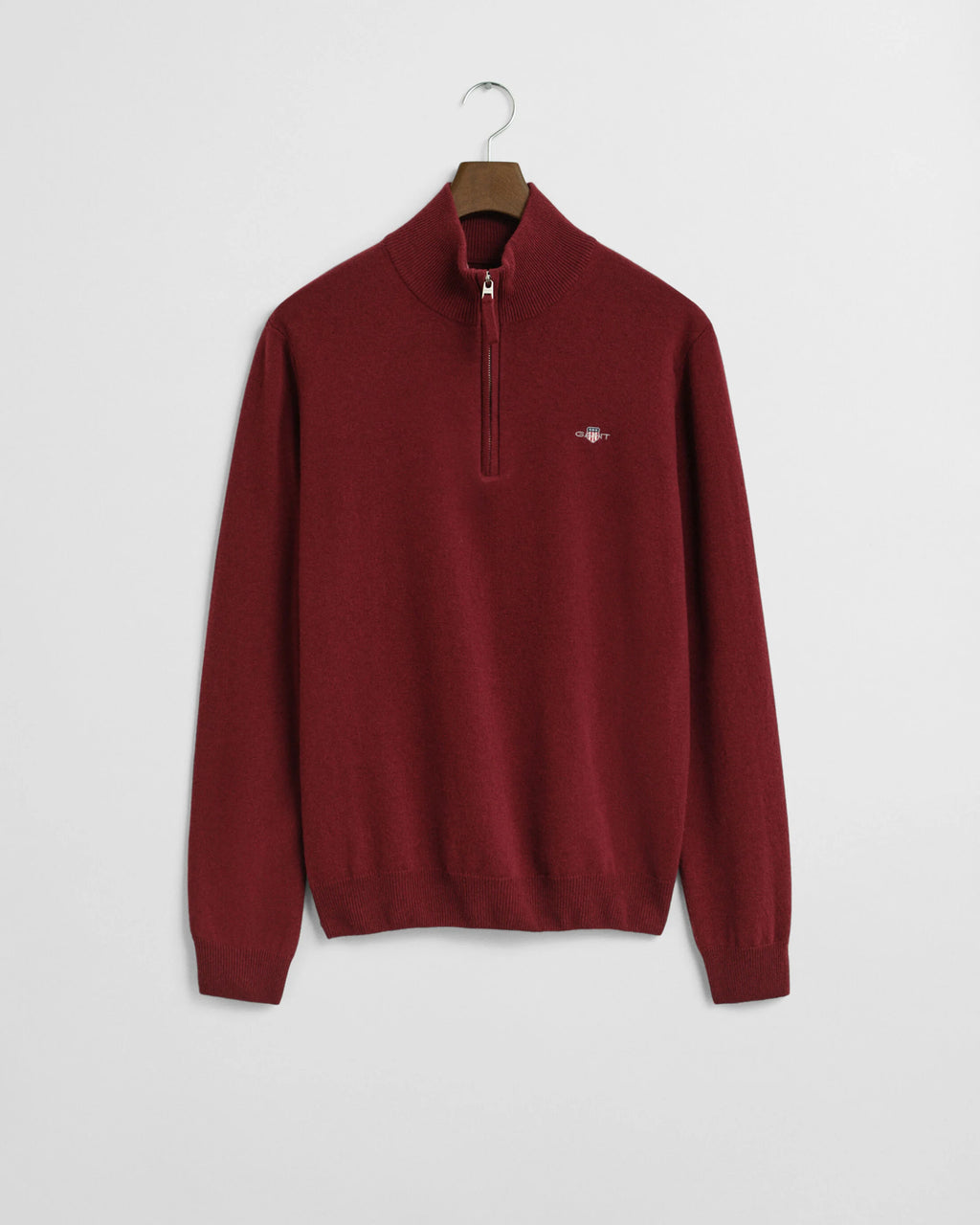 Red half-zip sweater on a hanger against a white background