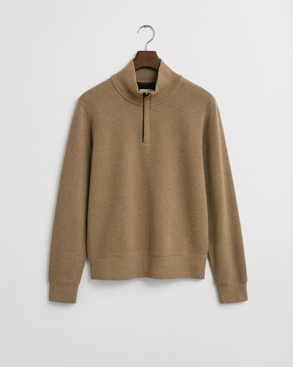 Brown sweater on a hanger against a light gray background